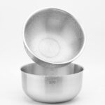 About Stainless steel mixing bowl with a strainer, perfect for kitchen use and food preparation.