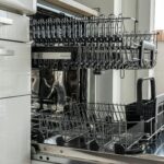 About Open and empty dishwasher in a sunlit modern kitchen ready for use.