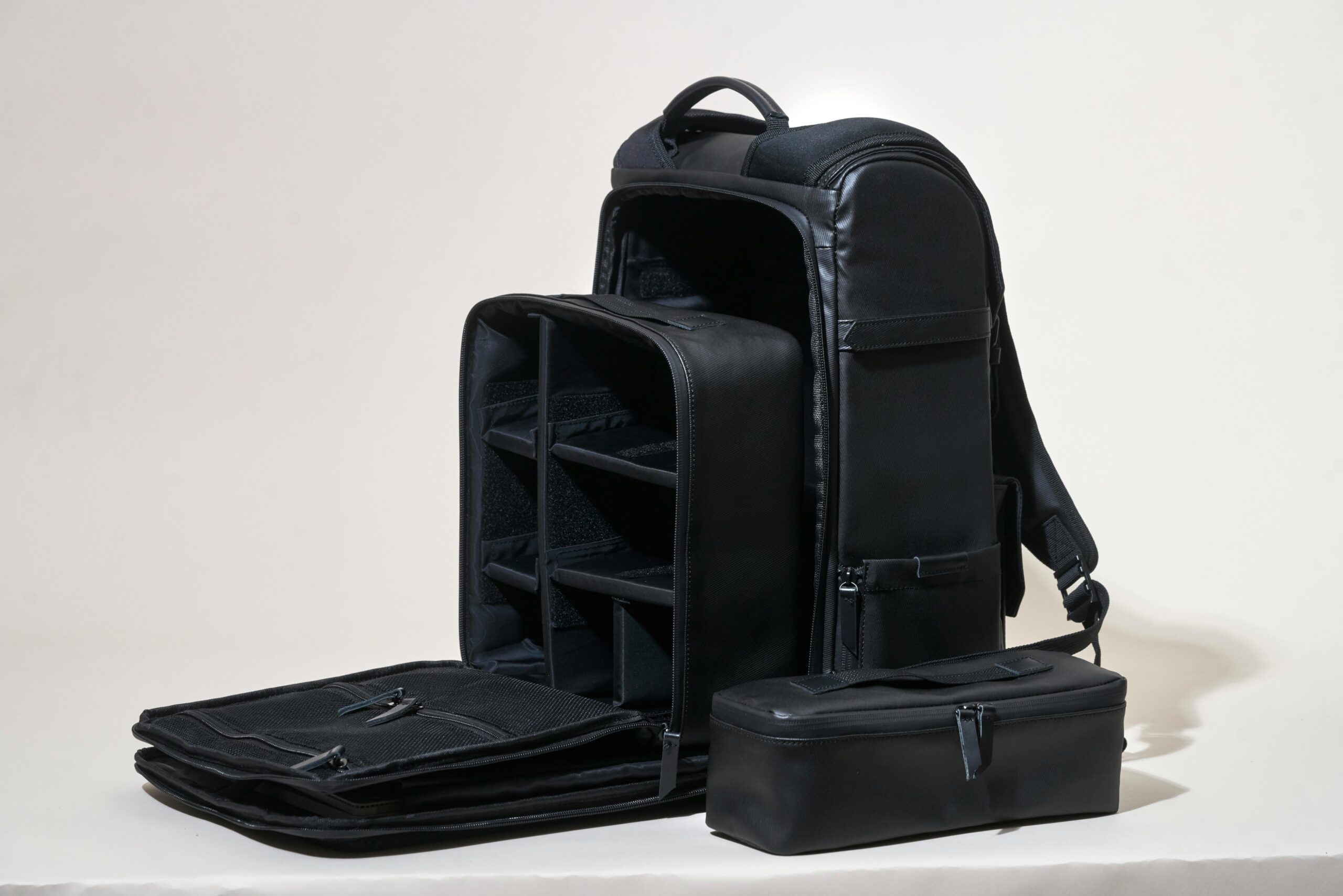 pexels photo 842959 842959 Sleek black leather camera bag showcasing compartments on a white background.