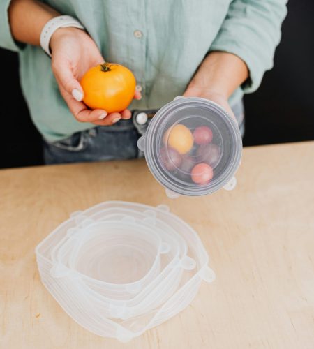 About Person holding fresh vegetables and using eco-friendly storage in kitchen.